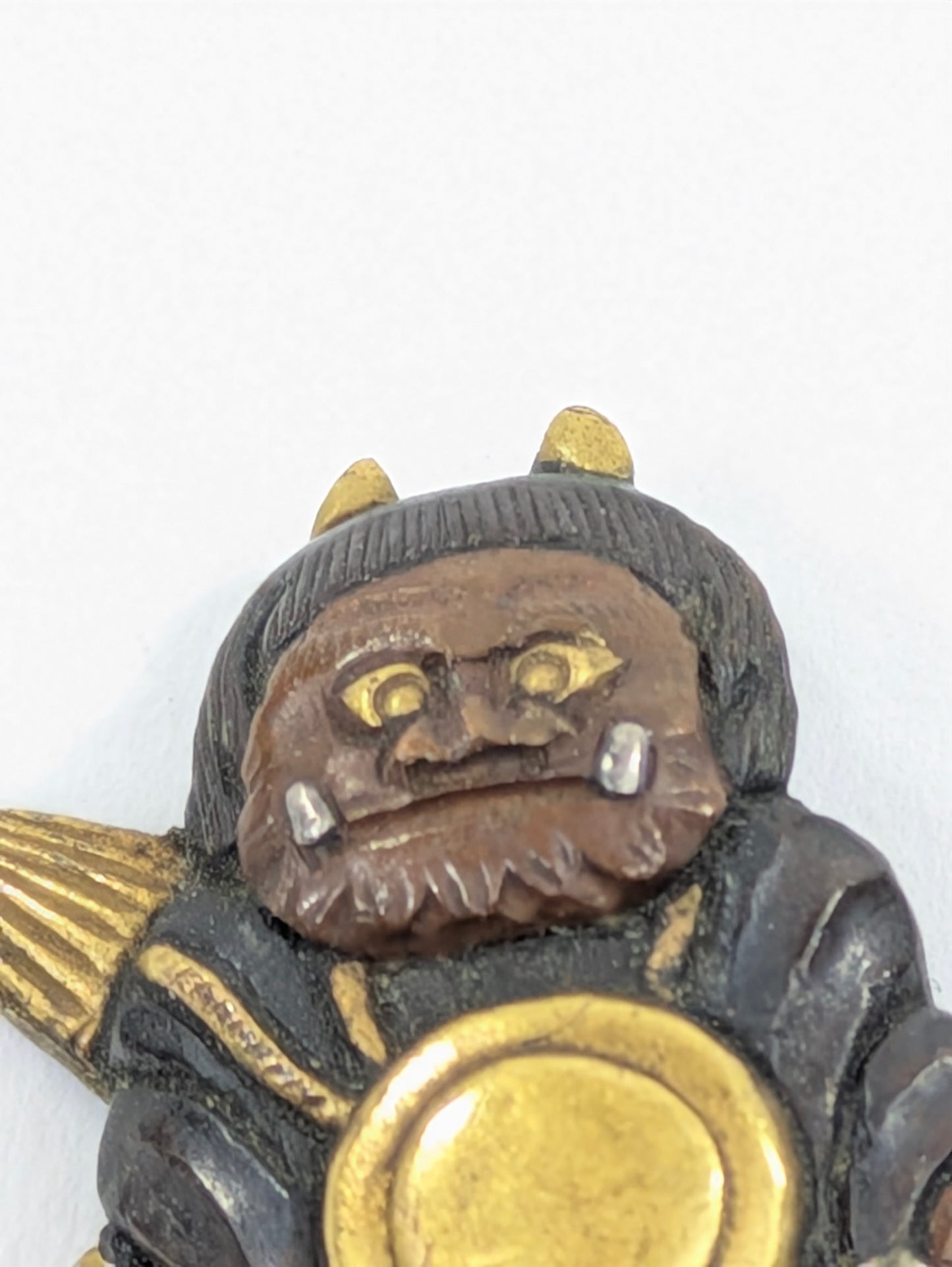 Menuki Oni Dressed as Monk with Drum and Scroll Japan, Edo period, mixed-metal with gilt highlights LS108